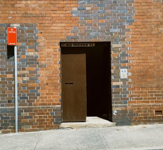 an open double door leads into a red brick building; no stopping sign in left corner of the image